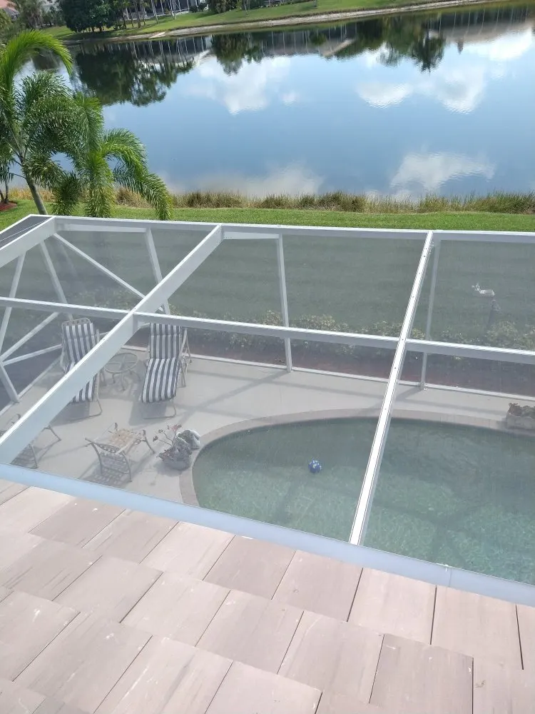 Pool cage roof from above, with a lake behind it